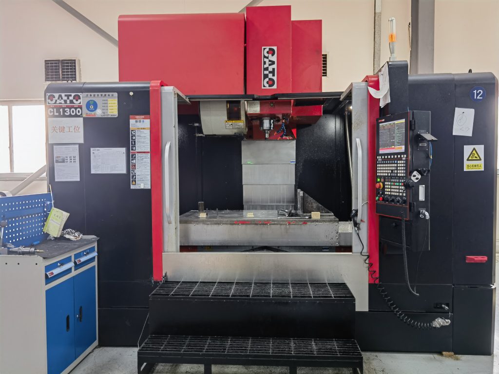 vertical milling machine with a work bed and cutting tool.