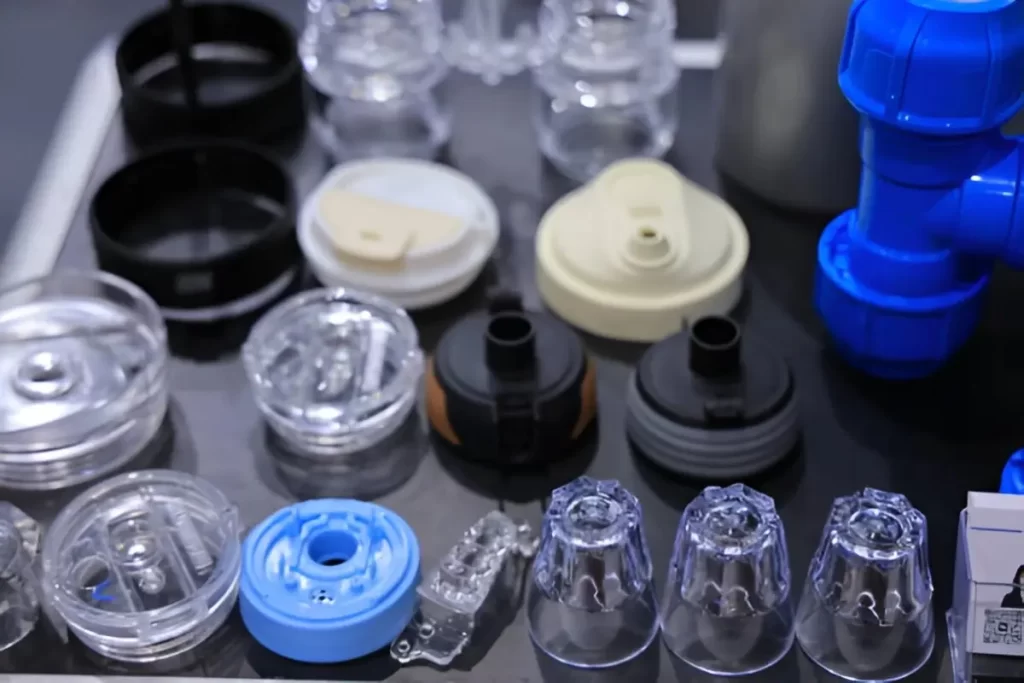 Acrylic molded products are neatly arranged in a row. The parts are clear, uniform, and show consistent quality in shape and finish.