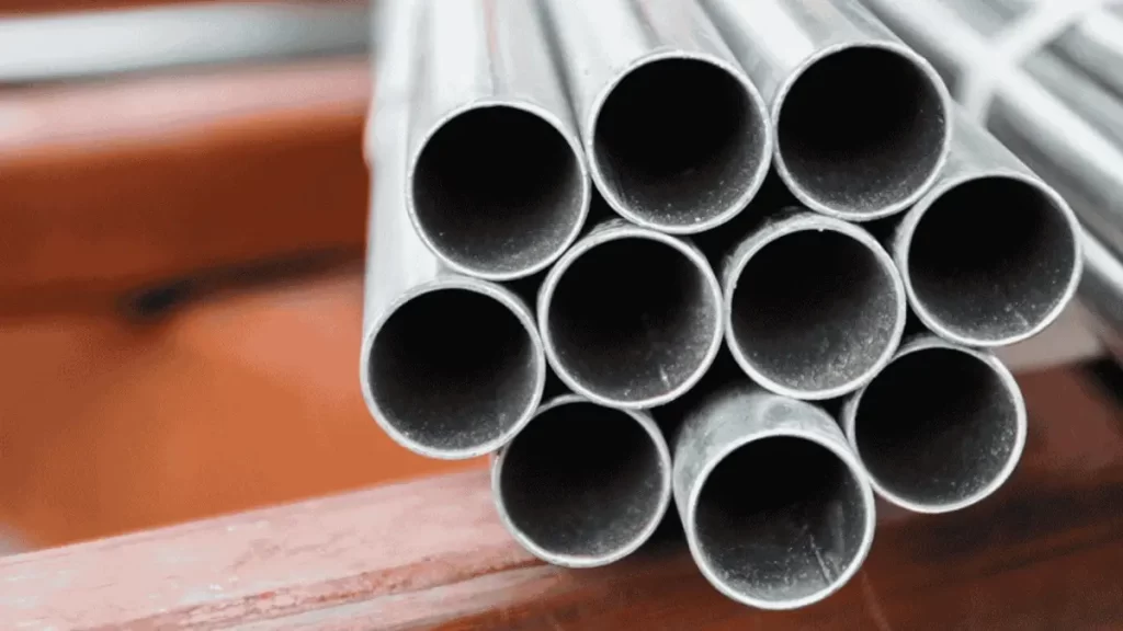 Close-up view of carbon steel pipes arranged together, highlighting their dark surface and hollow cylindrical form.
