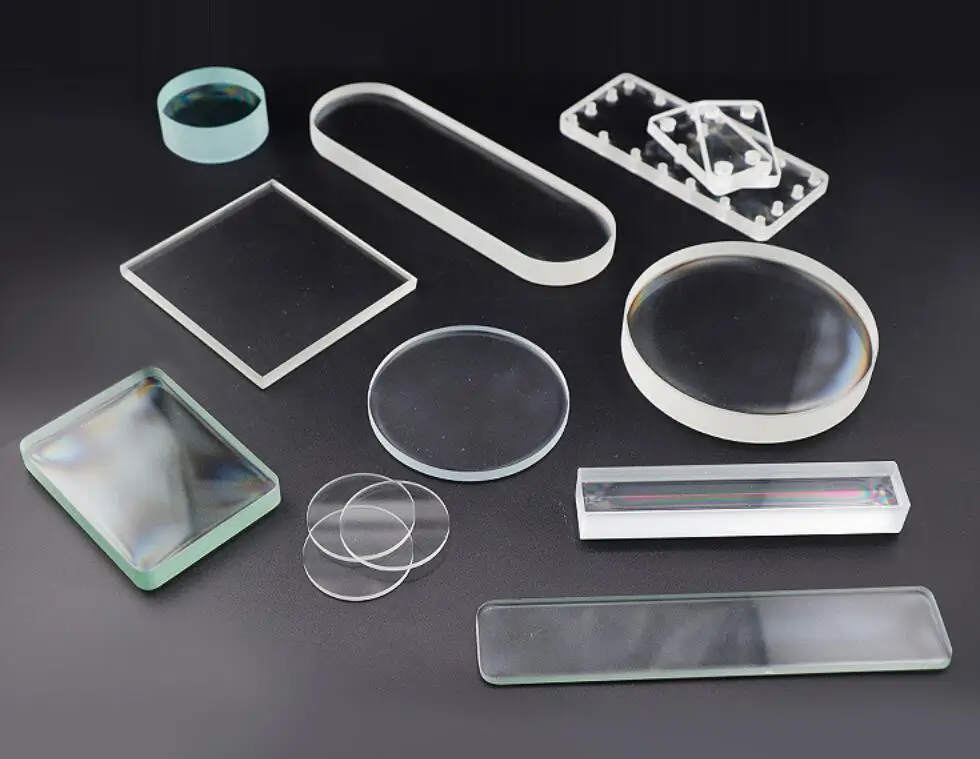 Transparent glass pieces of various shapes and sizes displayed on a black surface.