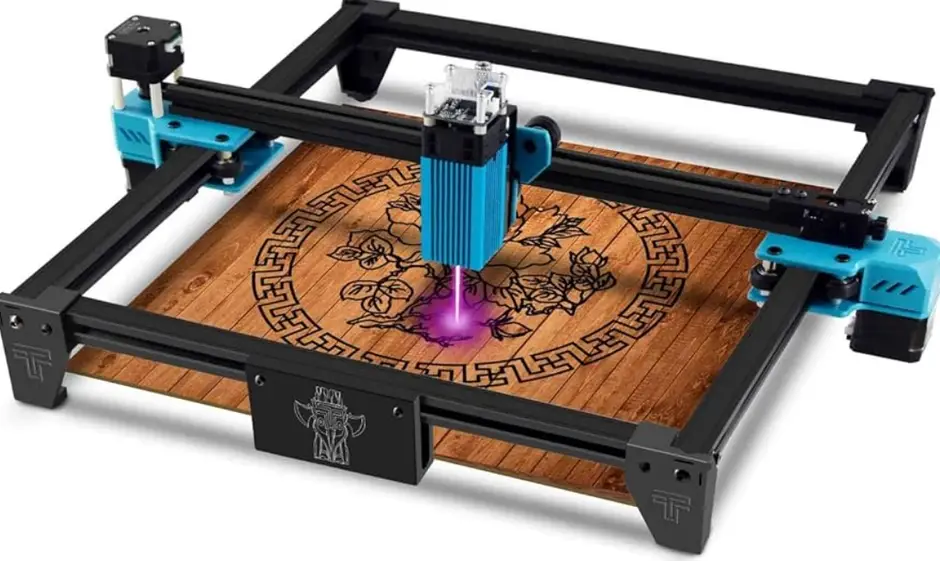 A compact blue and black CNC laser engraver using a powerful laser to engrave a wooden plate