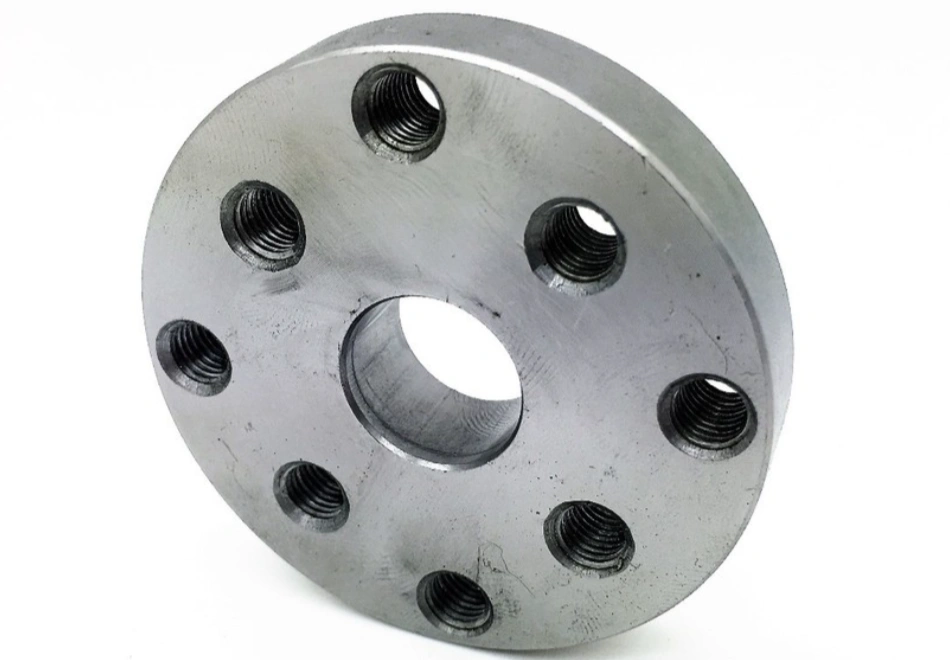 A CNC-machined water pump mounting flange with threaded bolt holes and a central hub opening