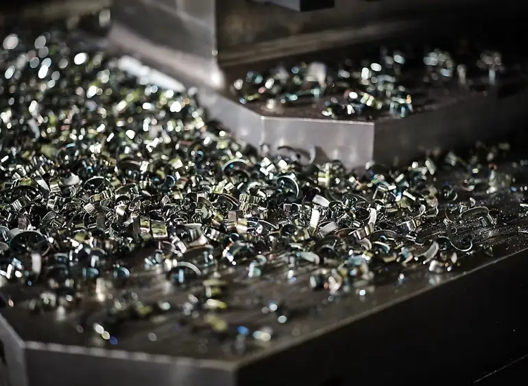 Metal chips and swarf accumulated on the CNC machine bed