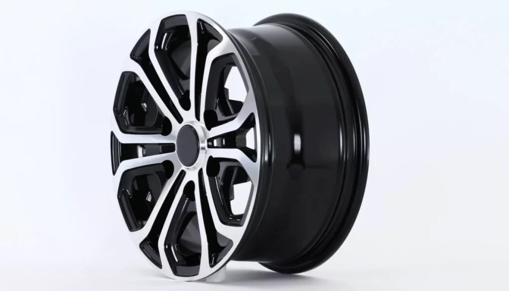 A shiny black and white aluminum alloy car wheel against a white background