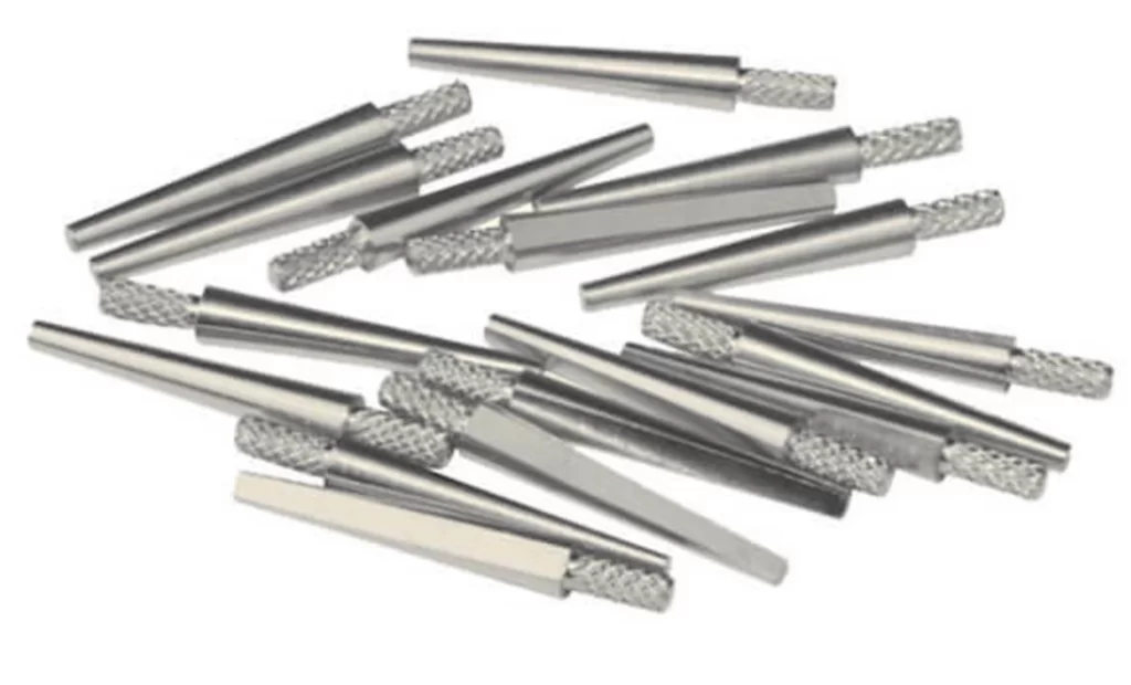 Multiple small, silvery pins with serrated ends, designed with precision for dental mold alignment