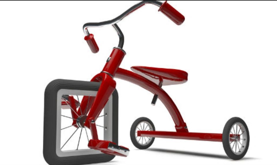 Red tricycle with square wheel, demonstrating costly design flaws without proper prototyping