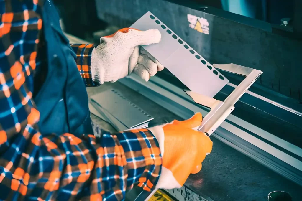 An engineer using a digital caliper to measure a custom sheet metal part.