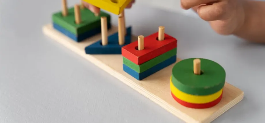 Colorful toys on a wooden fram with hands