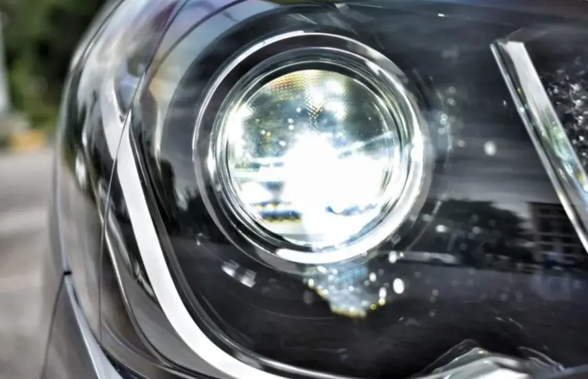 Close-up of a bright HID car headlight producing light
