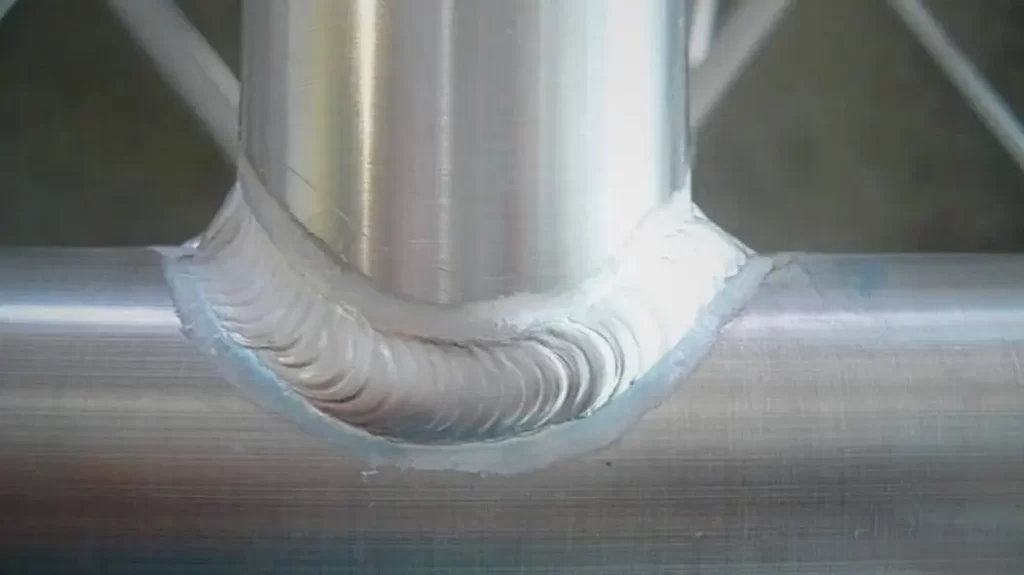 A detailed view of aluminum pipe welding, showing a 90-degree joint with the top and bottom sections aligned.