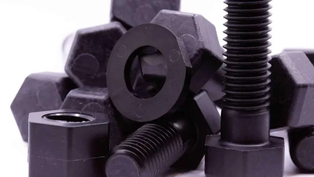A close-up of various black plastic nuts, bolts, and washers.
