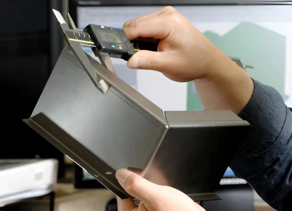 A digital caliper being used to check the dimensions of a part.