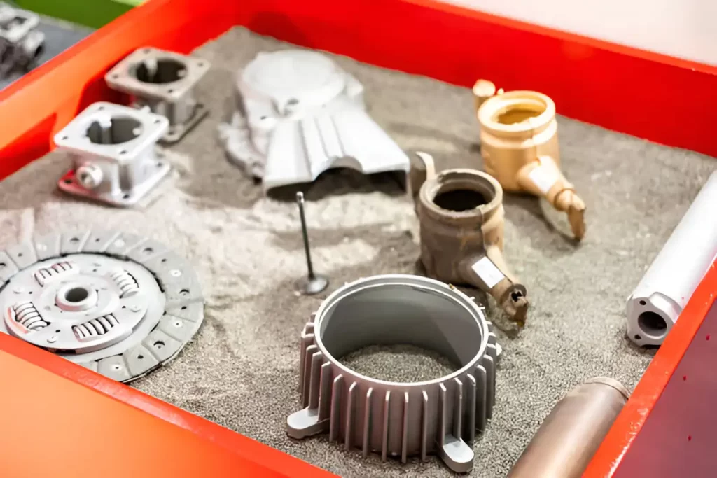 Sand casted prototype parts displayed in a box.