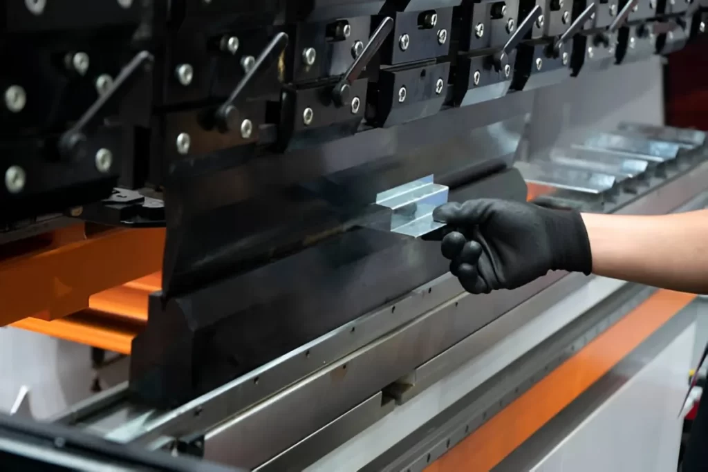 Image shows a fabricator bending a sheet metal part.