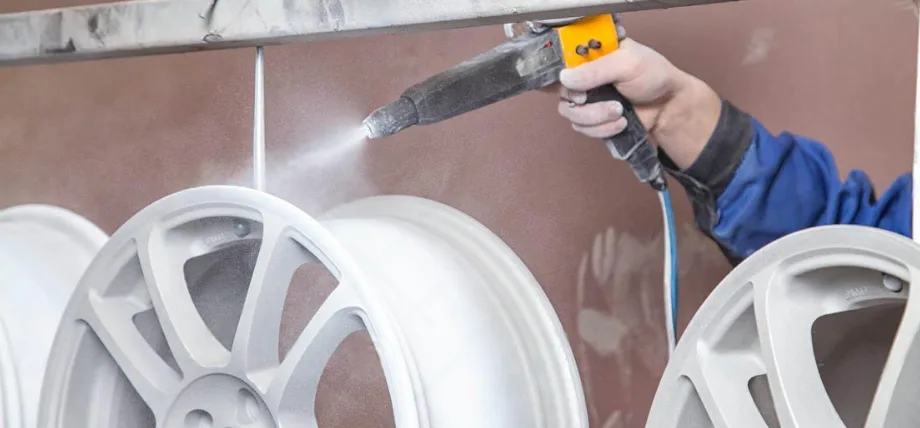 Spray gun with white spray on hanging aluminum wheels