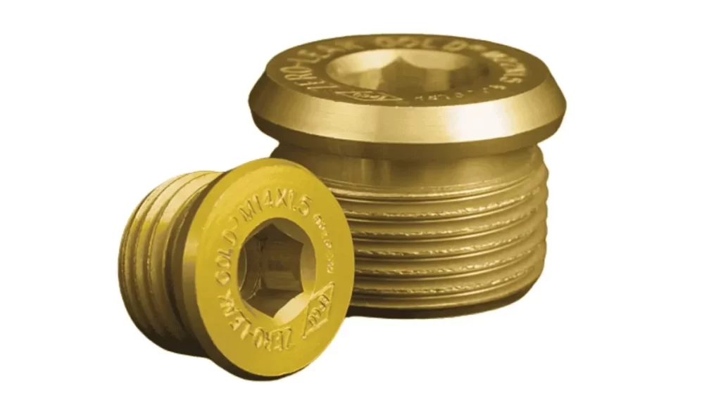 This is an aluminum plug with a Type II gold anodized finish. It is designed for automotive use and has dimensions written on the top head.