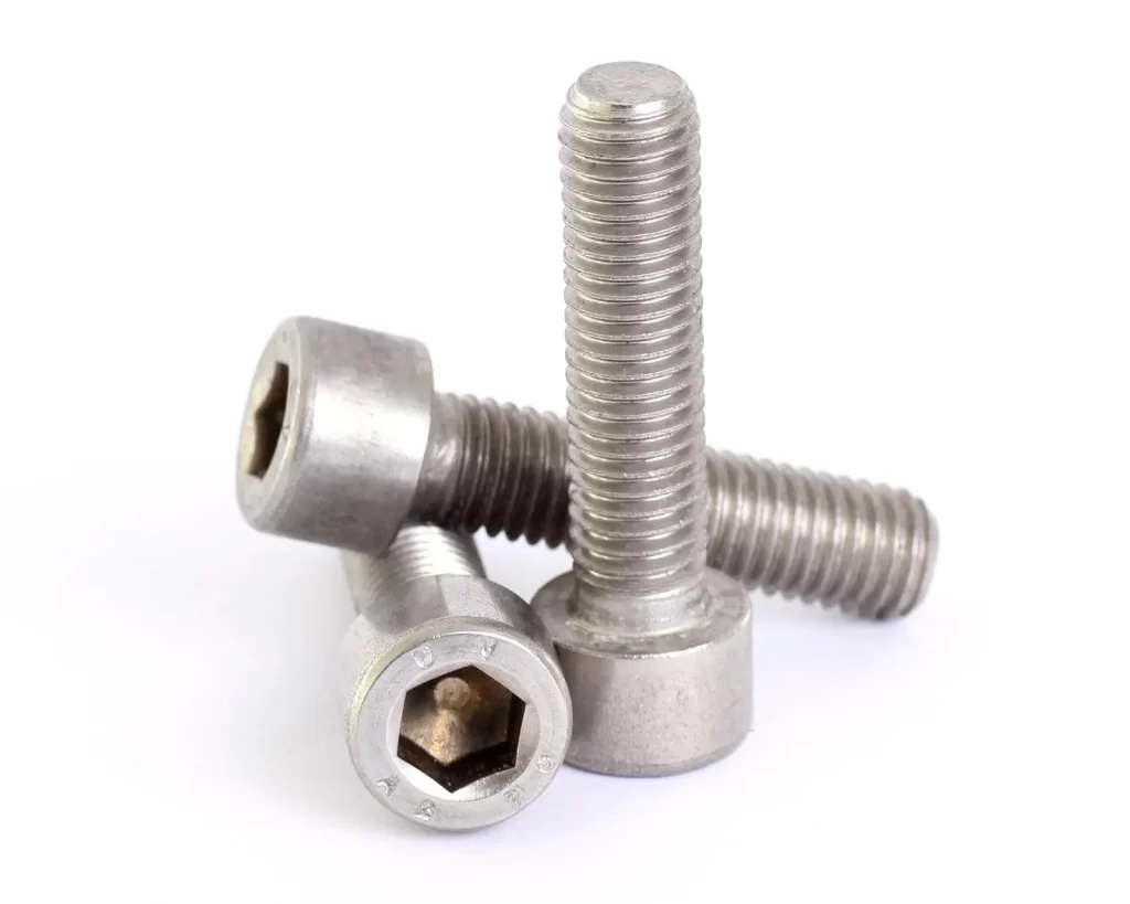 Three stainless steel round head screws lying with each other on a white background
