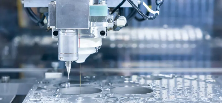 Wire EDM cutting circular cavities in molybdenum workpiece using thin electrode in dielectric fluid.